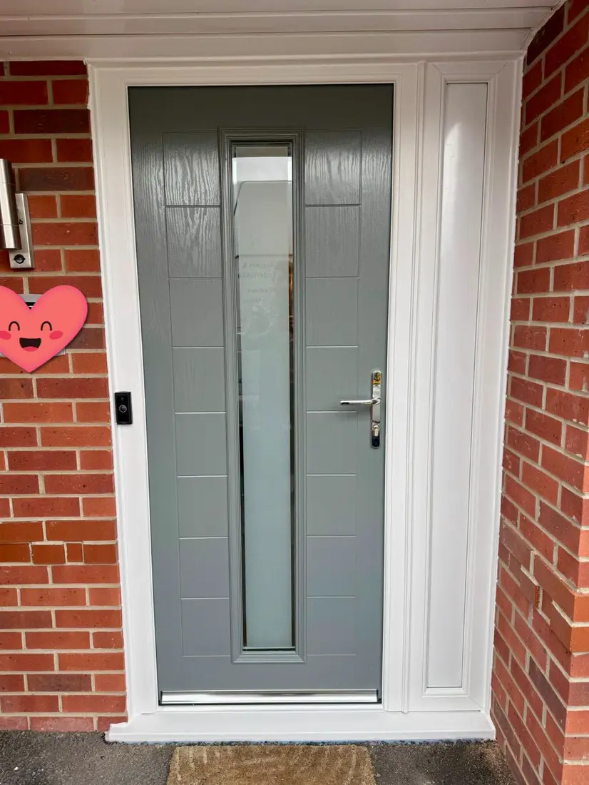 A light grey contemporary composite door with a tall glass strip