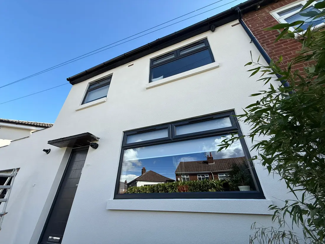 A white rendered house with new dark grey windows